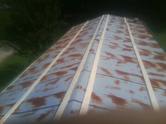 Rusted metal roof panels with new wood purlins before replacement — Storm Damage Roof Repair in Buckhead by Roofing Brothers