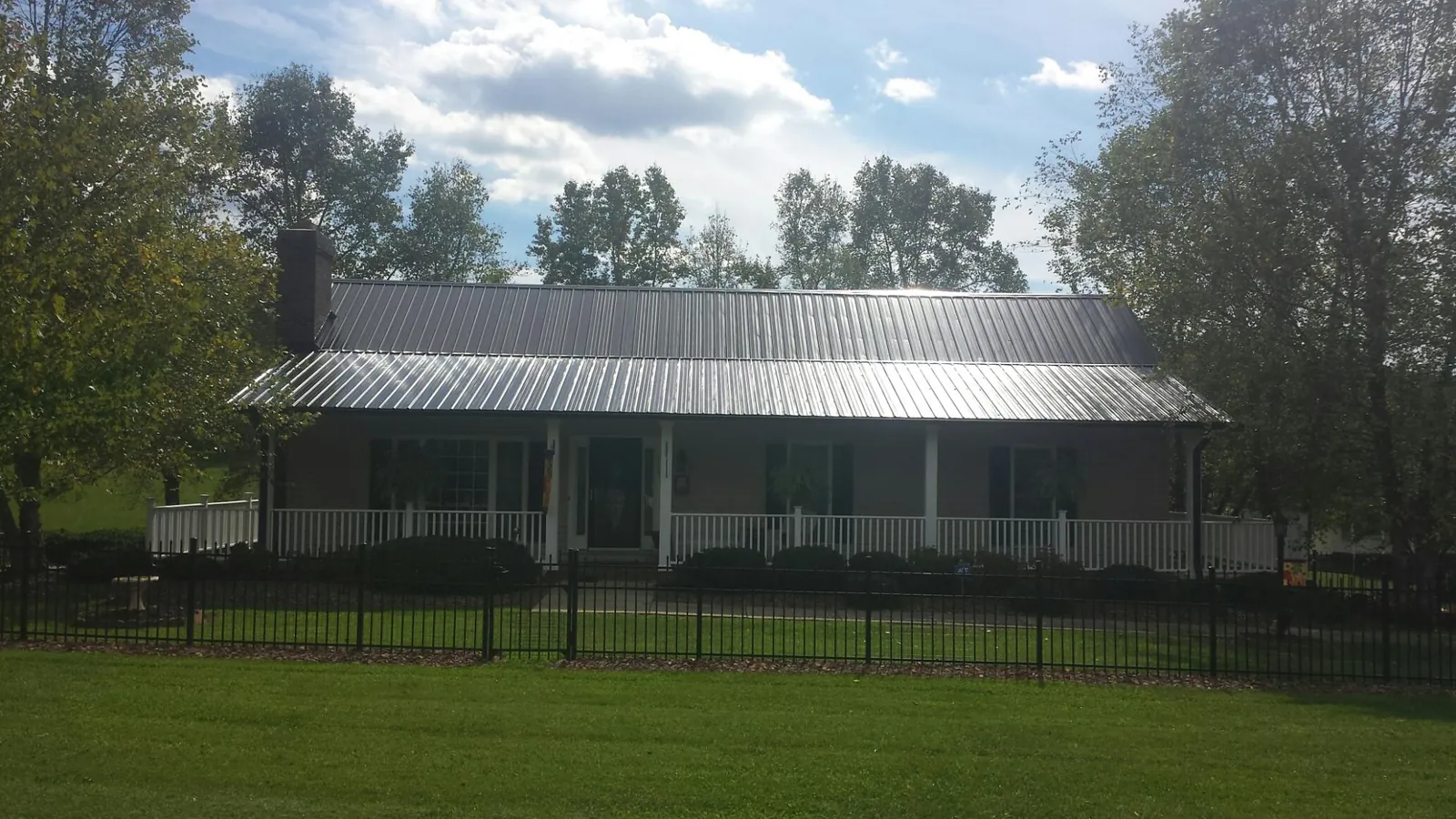 Gray metal roof on a brick ranch with a full width front porch — Gutter Guard Installation work by our crew in Buckhead