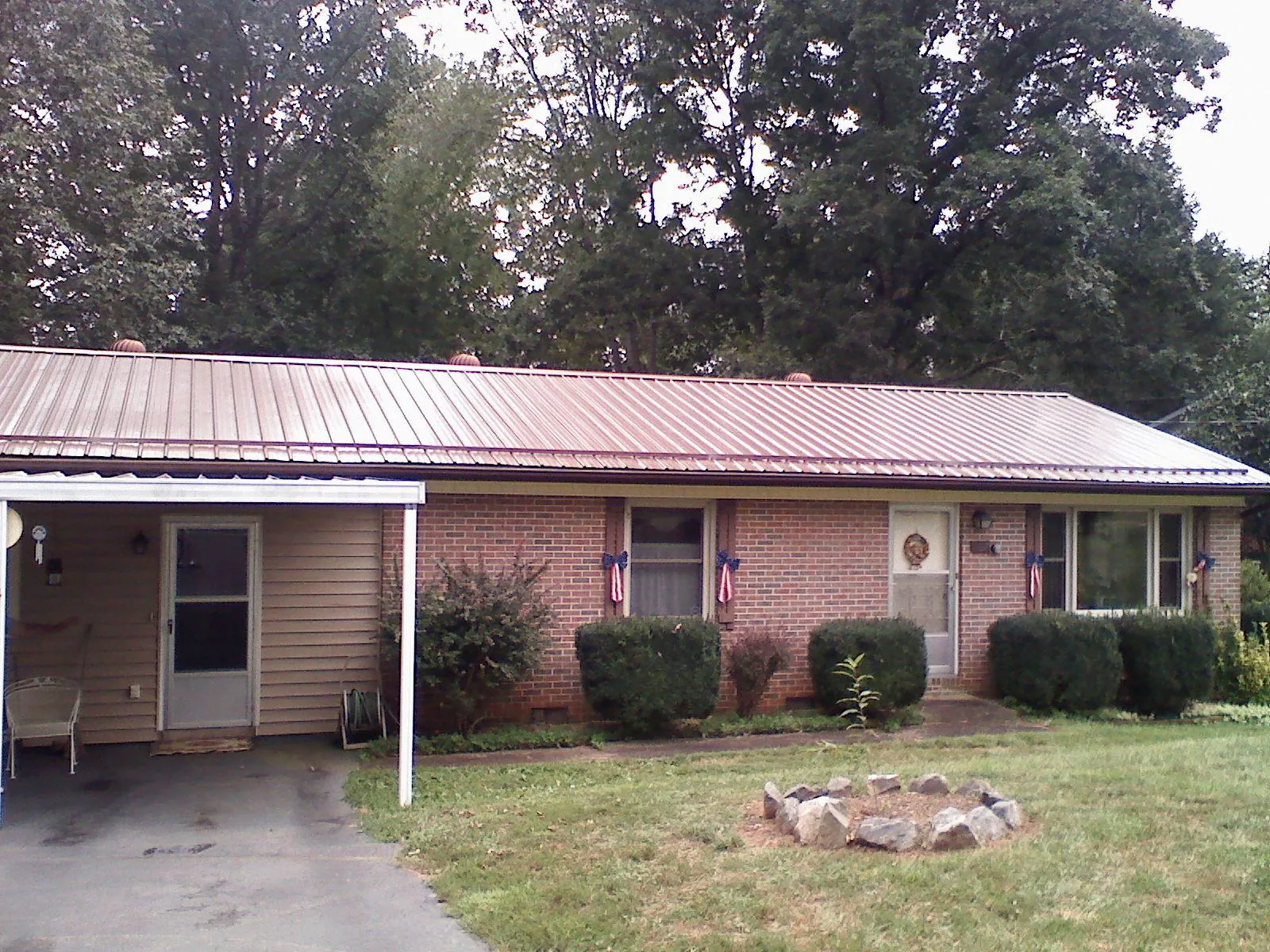 Bronze metal roof and carport on a brick ranch home — Roof Repair work by our crew in Buckhead