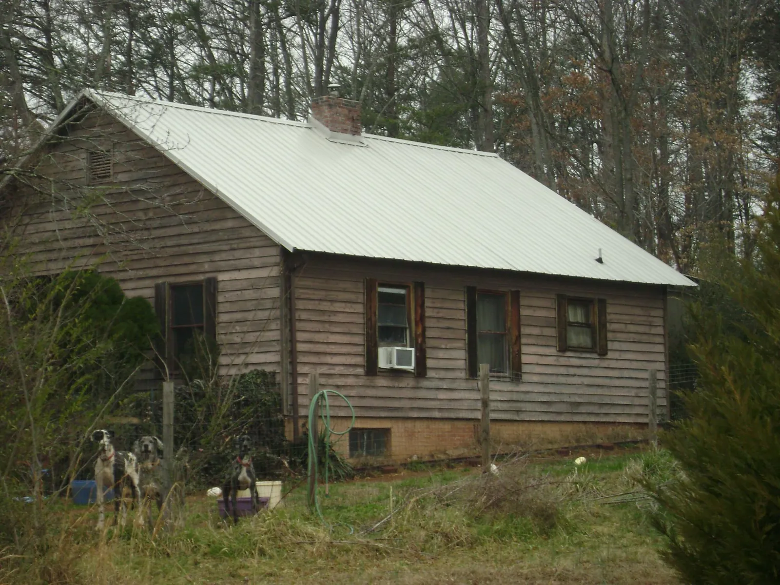 White metal roof on an old wood sided farmhouse, from a Metal Roof Installation job in Buckhead